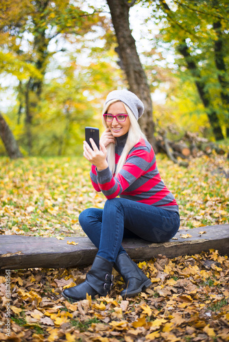 Beautiful young woman outside in nature making selfie