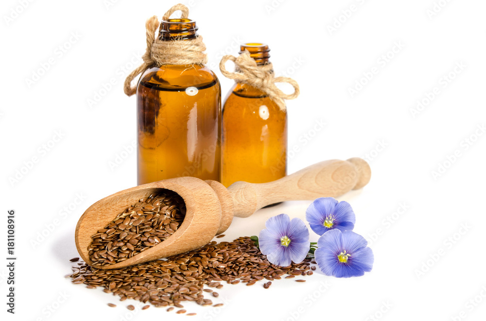 Flax seeds in the wooden scoop, bottles with oil and beauty flowers isolated on white background. Flax seeds in the wooden scoop, bottles with oil and beauty flowers isolated on white background.