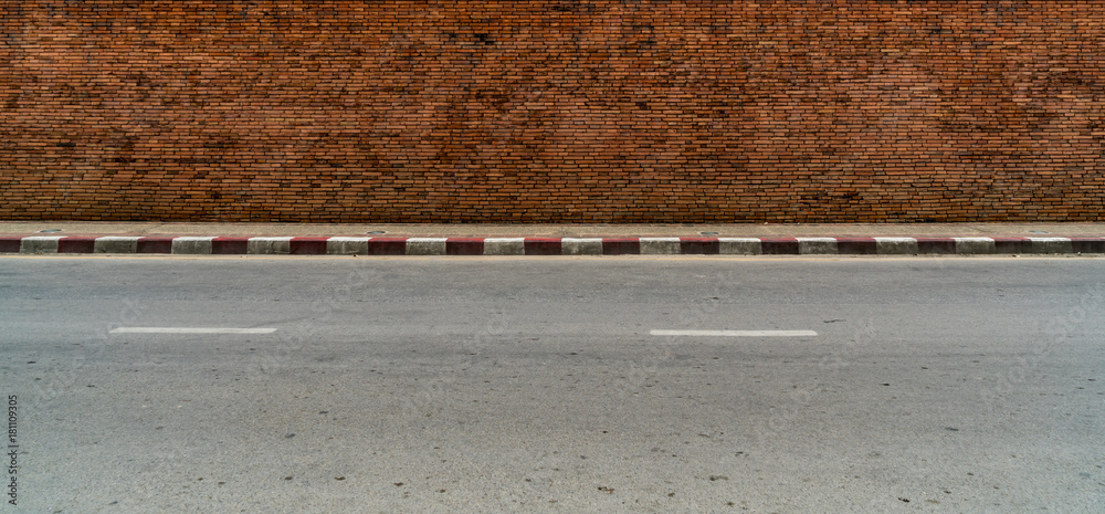Fototapeta premium old brick wall with concrete sidewalk