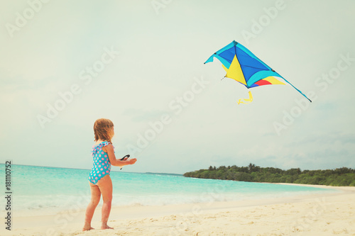 Little girl flying a kite on beach