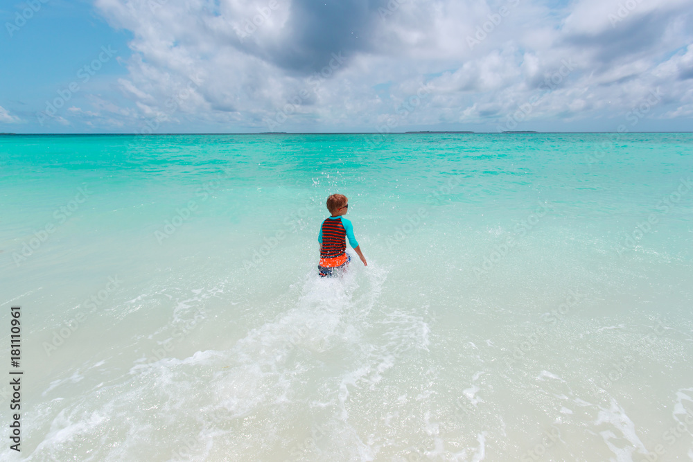 little boy go swim on tropical beach