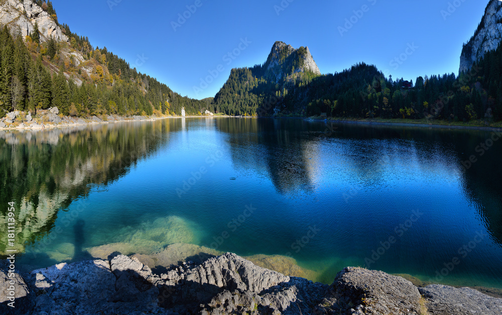 Naklejka premium Idyllic autumn scene in the Alps with mountain lake reflection.