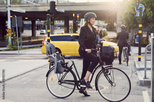 Mature businesswoman with bicycle on street in city