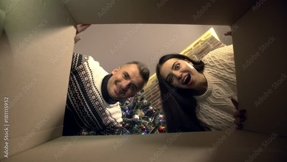 Young couple opening a Christmas present
