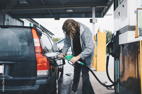 Full length of man refueling car at gas station photo