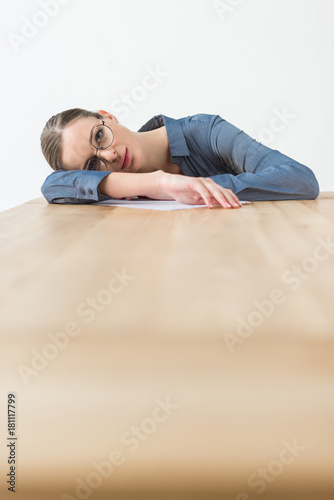 Tired businesswoman lying on table © LIGHTFIELD STUDIOS