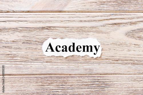 ACADEMY of the word on paper. concept. Words of ACADEMY on a wooden background