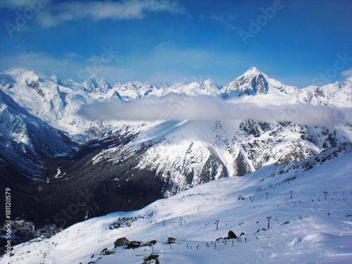 Views of snow capped mountains of Dombay. Winter Sunny day, mountain range, clouds