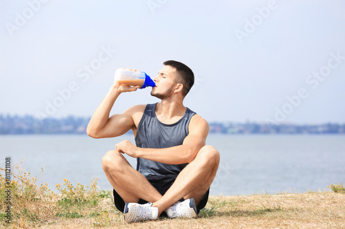 Handsome young man drinking...