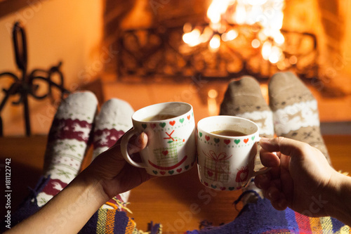 Man and woman in warm socks near fireplace. Happy couple.	