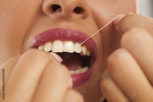 young beautiful woman cleans her teeth with dental floss © vladimirfloyd