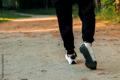 Morning jog in the park, men's legs close-up copy space