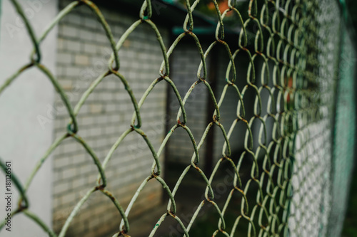 A close up of a green chain link fence on an angle.