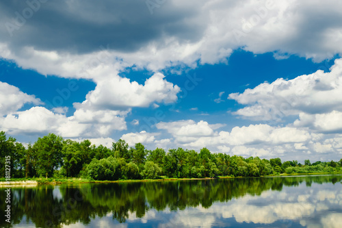 Beautiful summer rural landscape with river and clouds on the blue sky. Russia. Ural. Village Sloboda