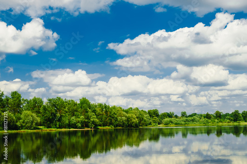 Beautiful summer rural landscape with river and clouds on the blue sky. Russia. Ural. Village Sloboda