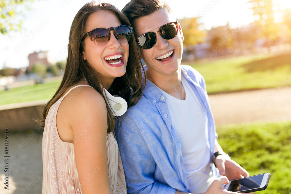 Beautiful young couple using they mobile phone in the park. Beautiful young couple using they mobile phone in the park.