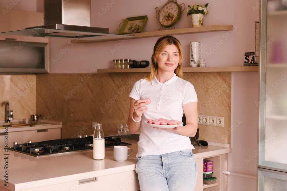 Process of making macaroon, french dessert. Homemade food. Woman holding a plate of tasty macaroons in the kitchen Process of making macaroon, french dessert. Homemade food. Woman holding a plate of tasty macaroons in the kitchen