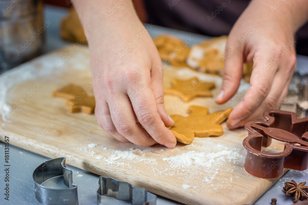Woman makes christmas gingerbread cookies. Dough and metal cutters on wooden table, horizontal