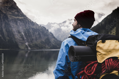 Austria, Tyrol, Alps, hiker standing at mountain lake photo