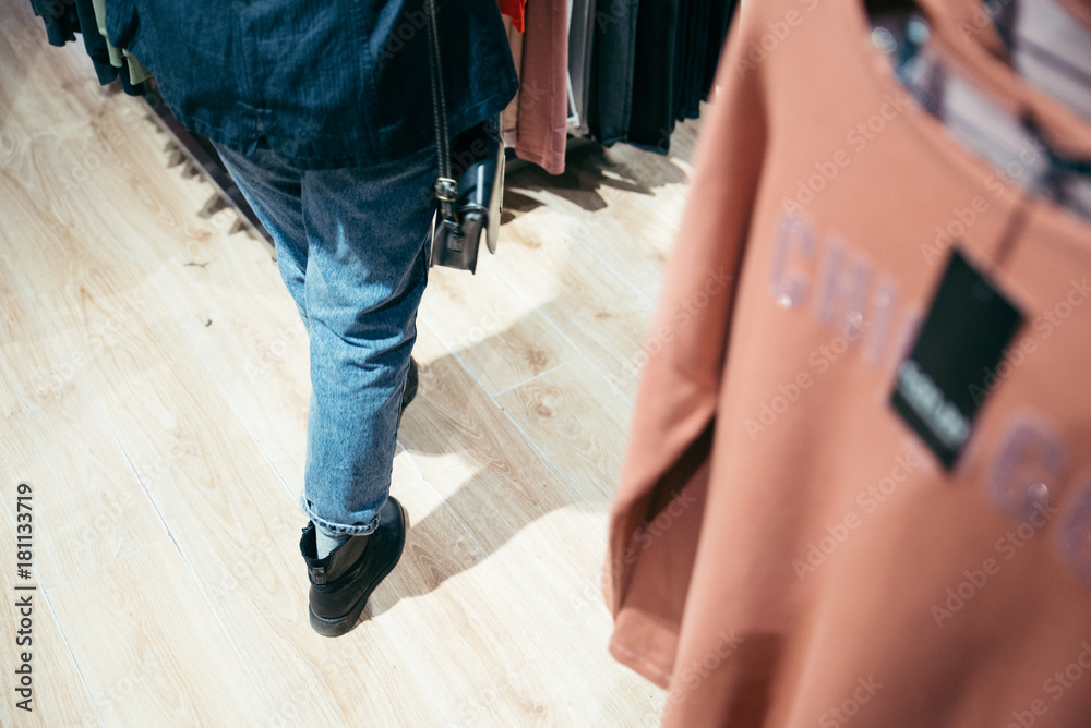 Fototapeta premium Woman looking at price tag of clothes in store