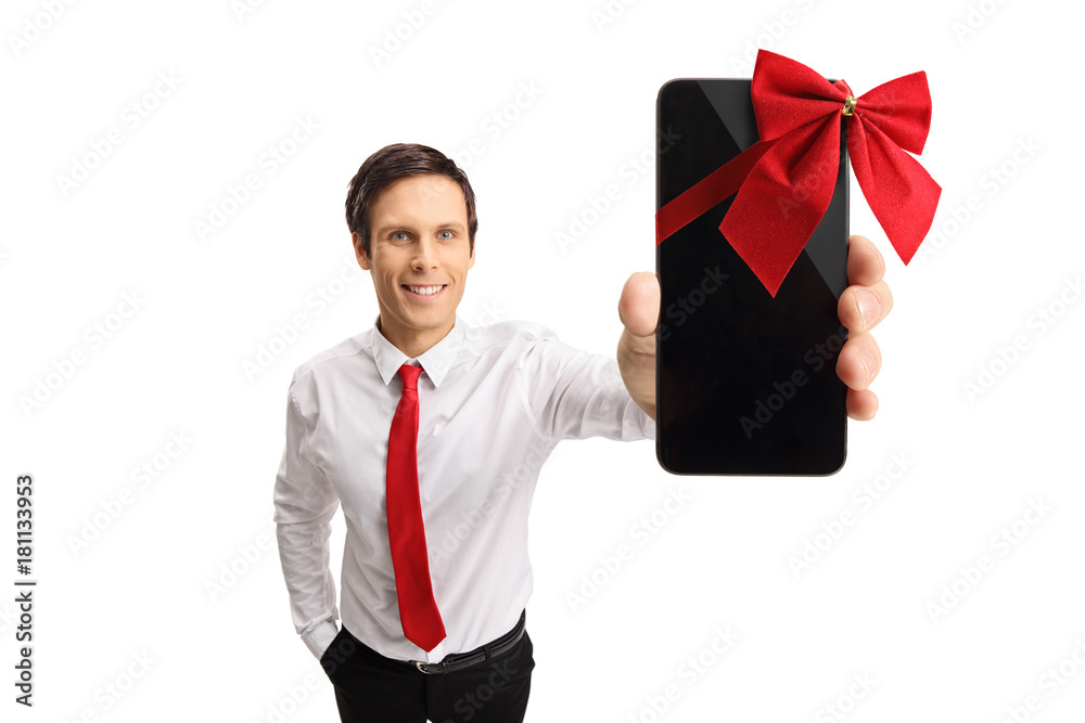 Formally dressed guy showing a phone wrapped with a red ribbon as a gift Formally dressed guy showing a phone wrapped with a red ribbon as a gift