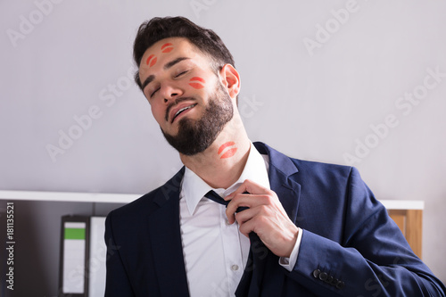 Businessman With Lipstick Kiss Marks On Face