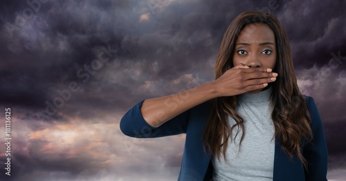 Woman with hand over mouth and dark clouds