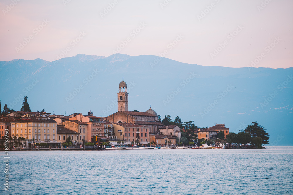 Lago di Garda city salo sunset on a lake on a background of high mountains. Italy in summer