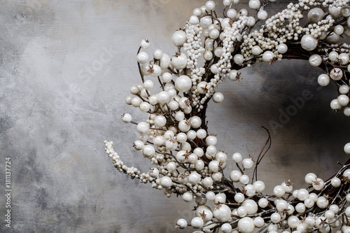 christmas wreath of branches with berries on a gray background with divorces on the right