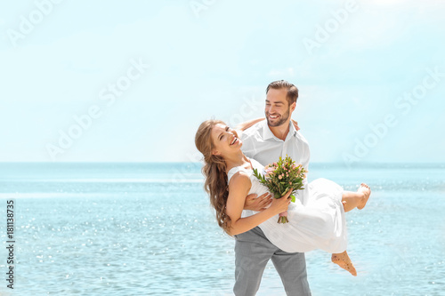Happy groom holding bride i...