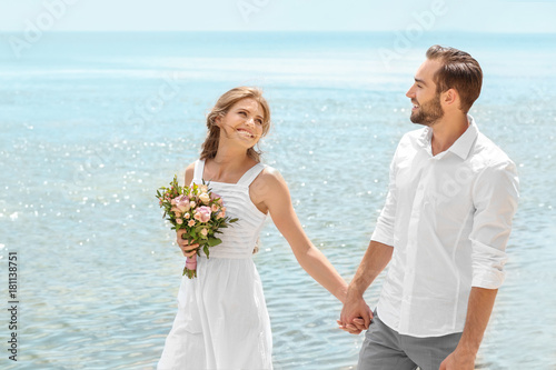 Happy newlywed couple walki...