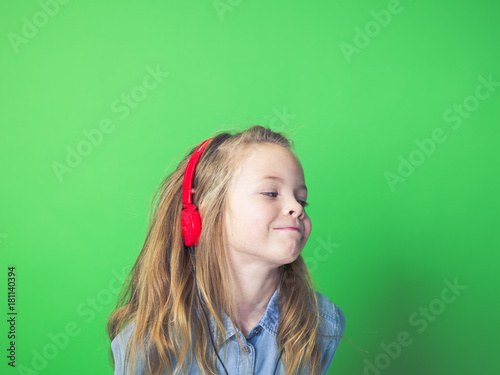 beautiful girl with red headphones in front of green background in the studio