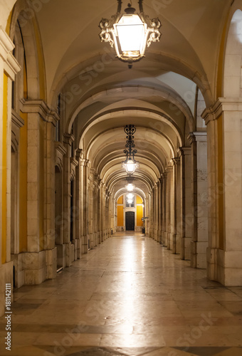 Archway along Commerce Square in Lisbon at night.