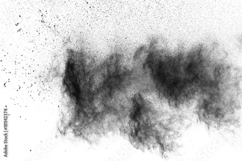 Black powder explosion. The particles of charcoal splatter on white background. Closeup of black dust particles splash isolated on background.