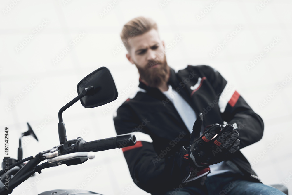 A young guy with a beard sits on his electric motorcycle. A young guy with a beard sits on his electric motorcycle.