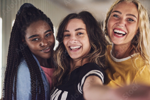 Quadro su tela Diverse group of young female friends taking a selfie together