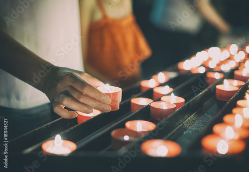 Woman puts a candle on altar in church. photo