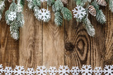 spruce branches with snow on wooden background