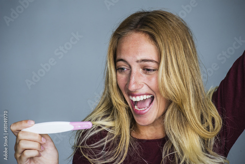 Young woman celebrating results of pregnancy test photo