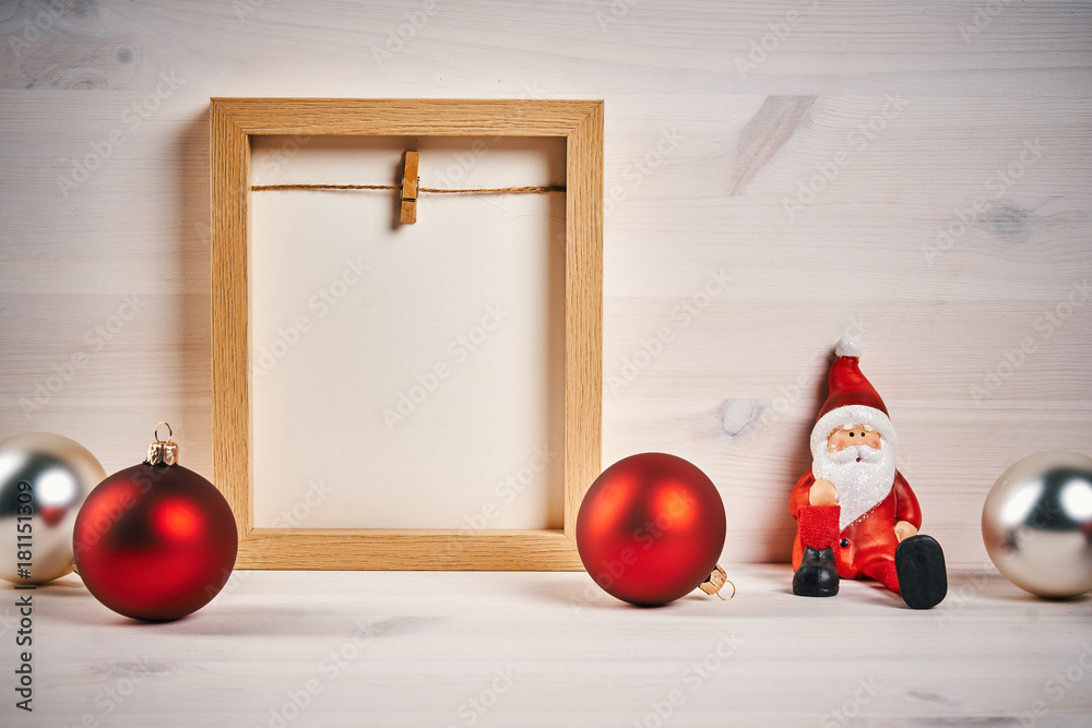 Fototapeta premium Christmas card with decorations on a wooden table with blank frame