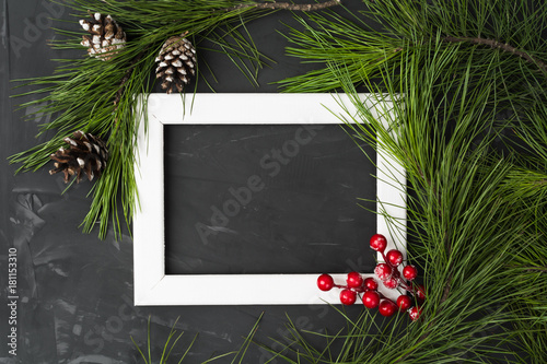White wooden frame with fir tree, pinecones and berries decoration