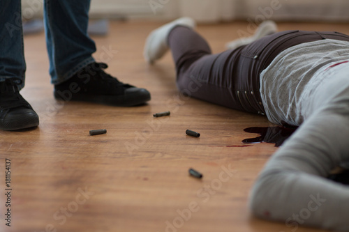 criminal with dead body and bullets at crime scene