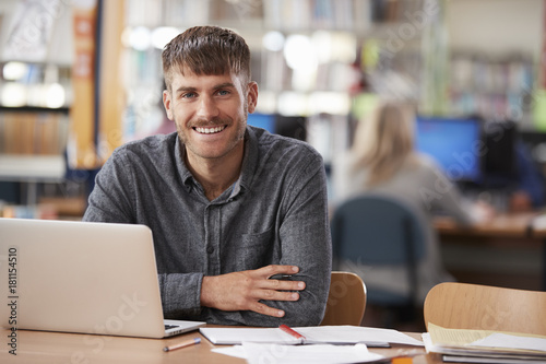 Portrait Of Mature Male Student Using Laptop In Library