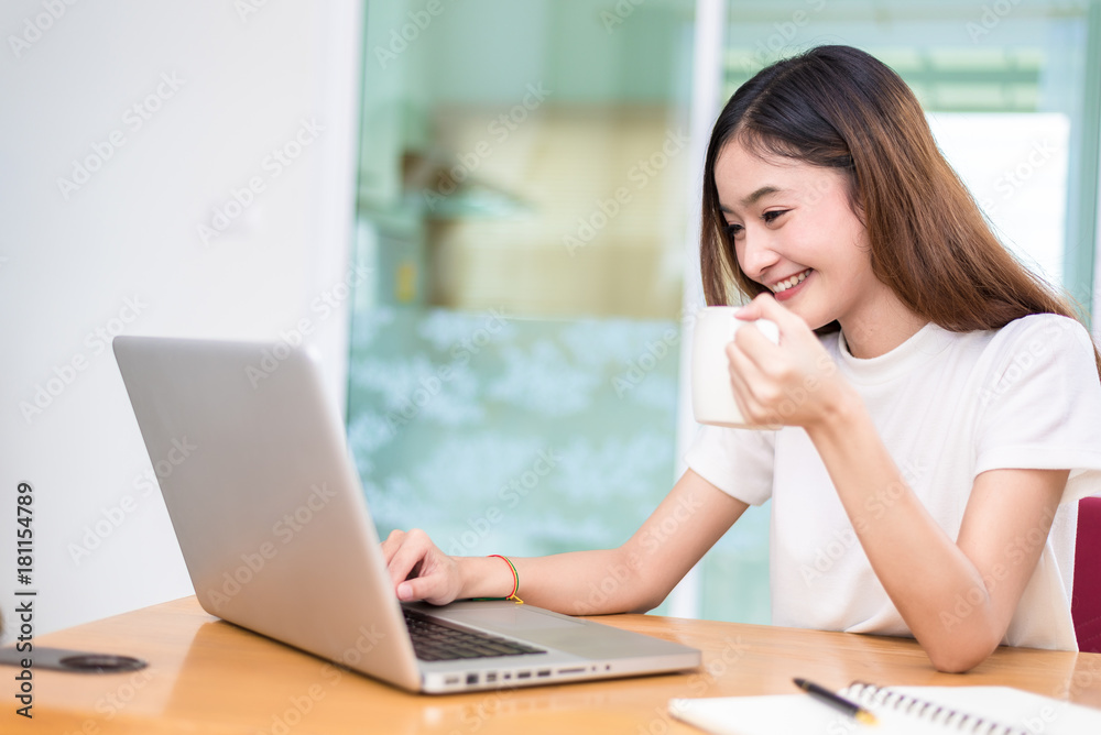 Asian woman enjoy herself while using laptops and internet in office. Business and marketing and part time concept. On line shopping and business success theme. Happy mood doing working job. Asian woman enjoy herself while using laptops and internet in office. Business and marketing and part time concept. On line shopping and business success theme. Happy mood doing working job.