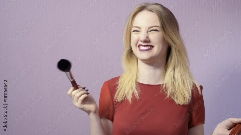 Beautiful blonde with makeup brushes in hands Beautiful blonde with makeup brushes in hands