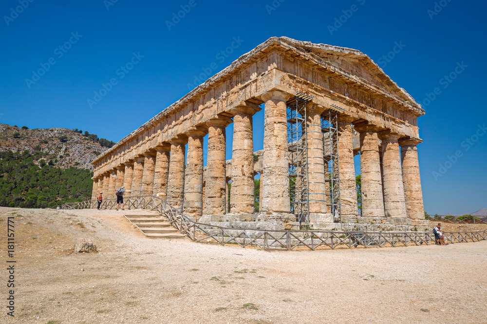 Some tourists visiting ancient Greek temple at Segesta in Sicily, Italy.