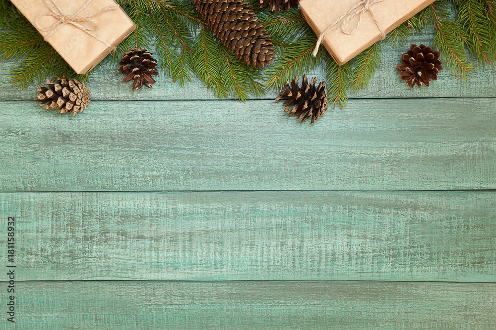 Christmas background or Xmas card  with decorations fir branches, pine cones on the wooden green backtop. Space for holiday text. Postcard  vintage style. Top view and flat