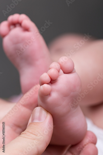 Mother giving baby foot massage against colic
