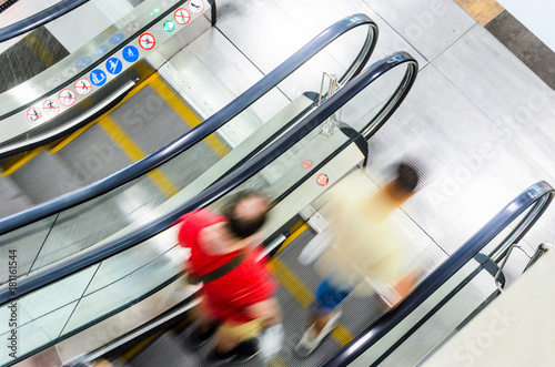 People on Escalator Motion Blurred, Top View. Abstract Blur Background of Moving Staircase