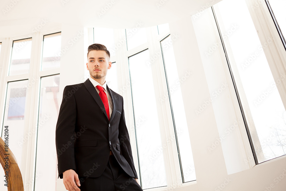 Portrait of young businessman walking on stair in business building Portrait of young businessman walking on stair in business building